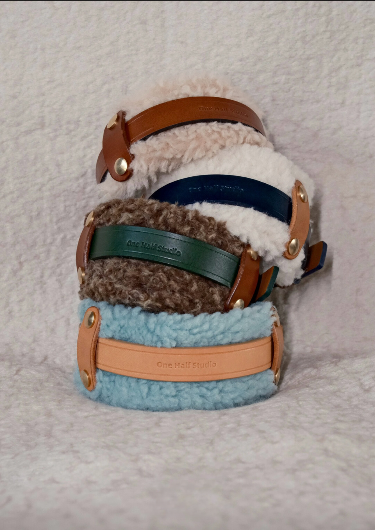 Stack of handmade Merino wool, this leather dog collars, featuring cozy and stylish designs in neutral and pastel tones.