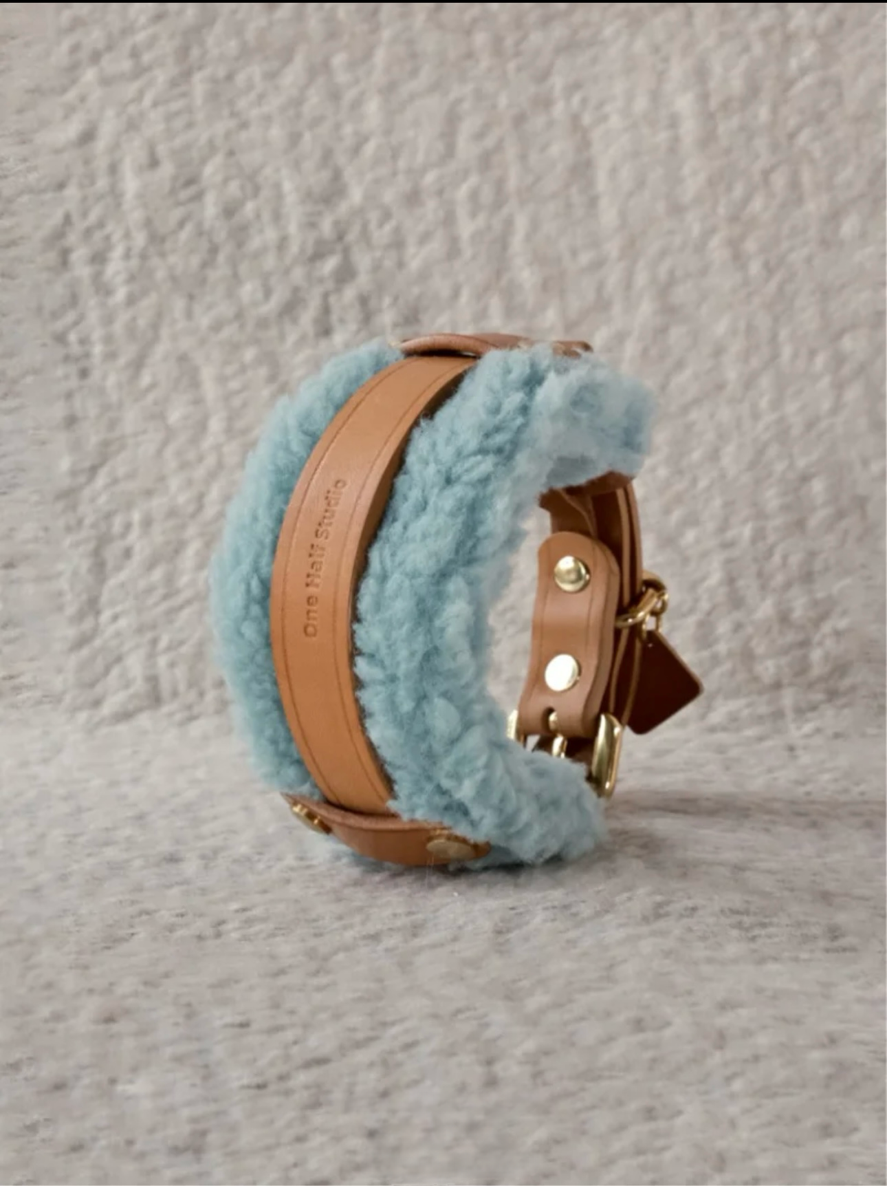 Stack of handmade Merino wool leather dog collars, featuring cozy and stylish designs in neutral and pastel tones.